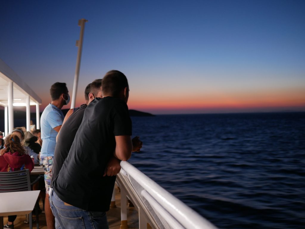Men leaning on a boat rail, Greece