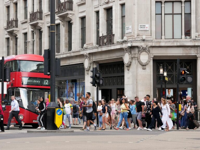 People and buses crossing the Oxford Circus, London.