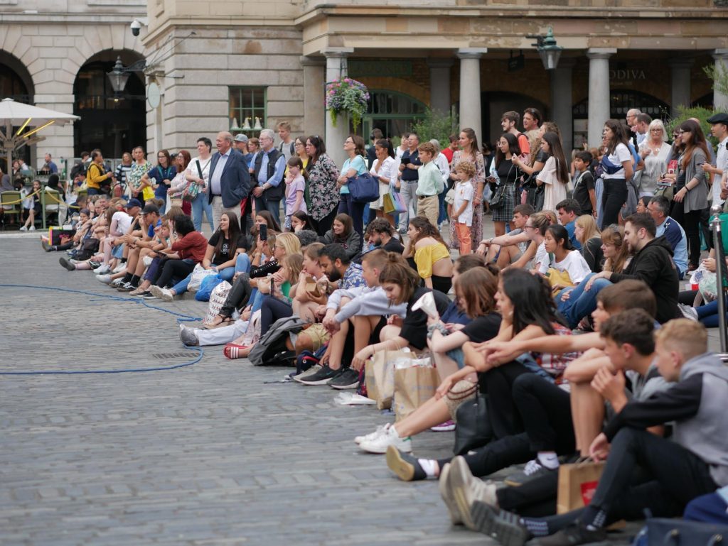 People watching a street performance at the Covent Garden Piazza in London.