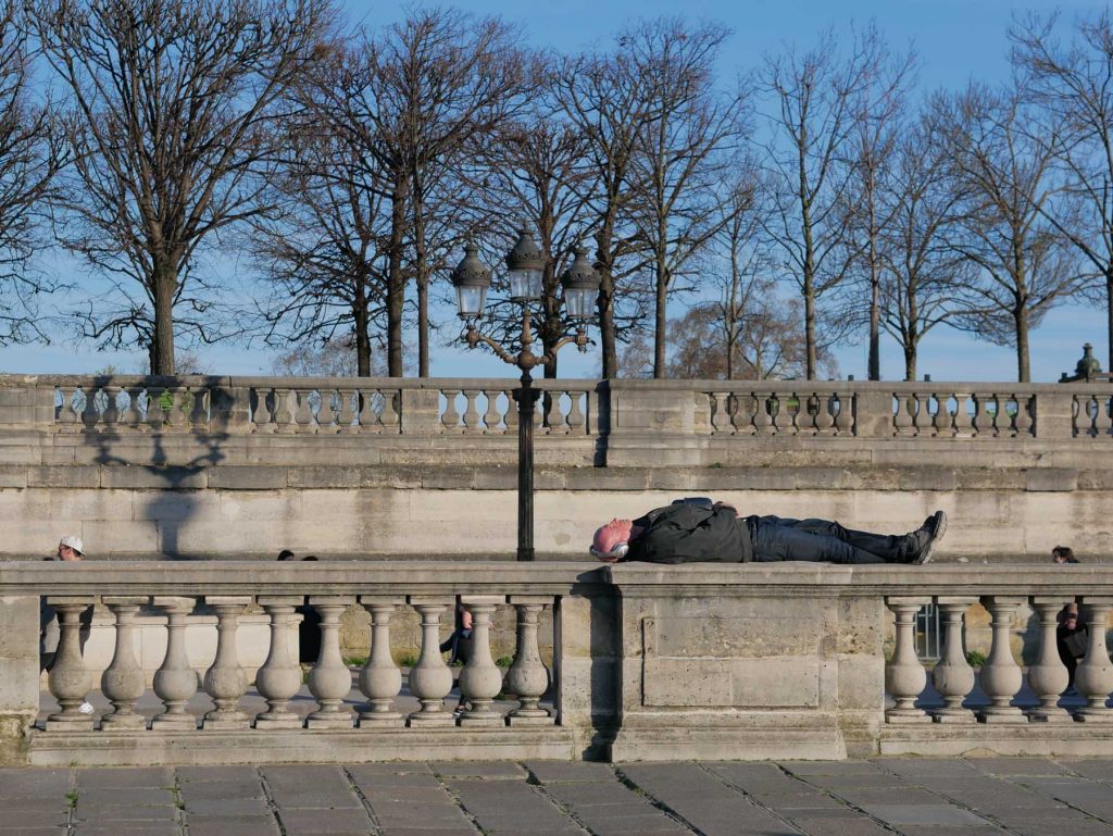 Man sleeping on a balustrade, Place de la Concorde, Paris.
