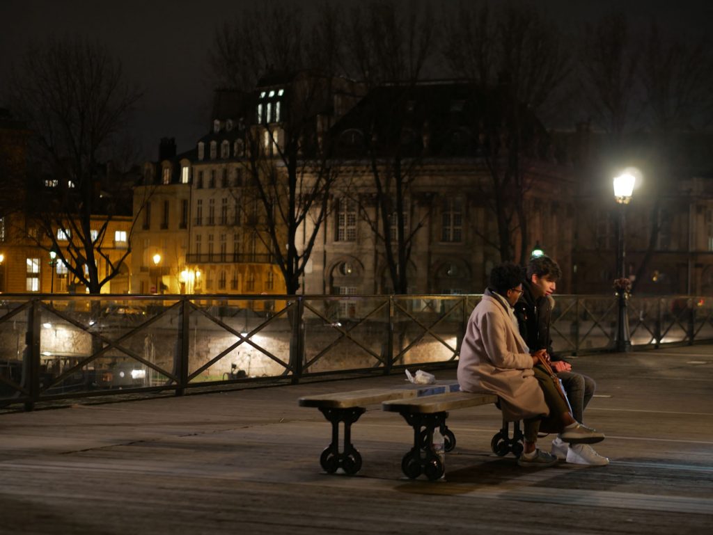 couple sitting on a Parisian bridge