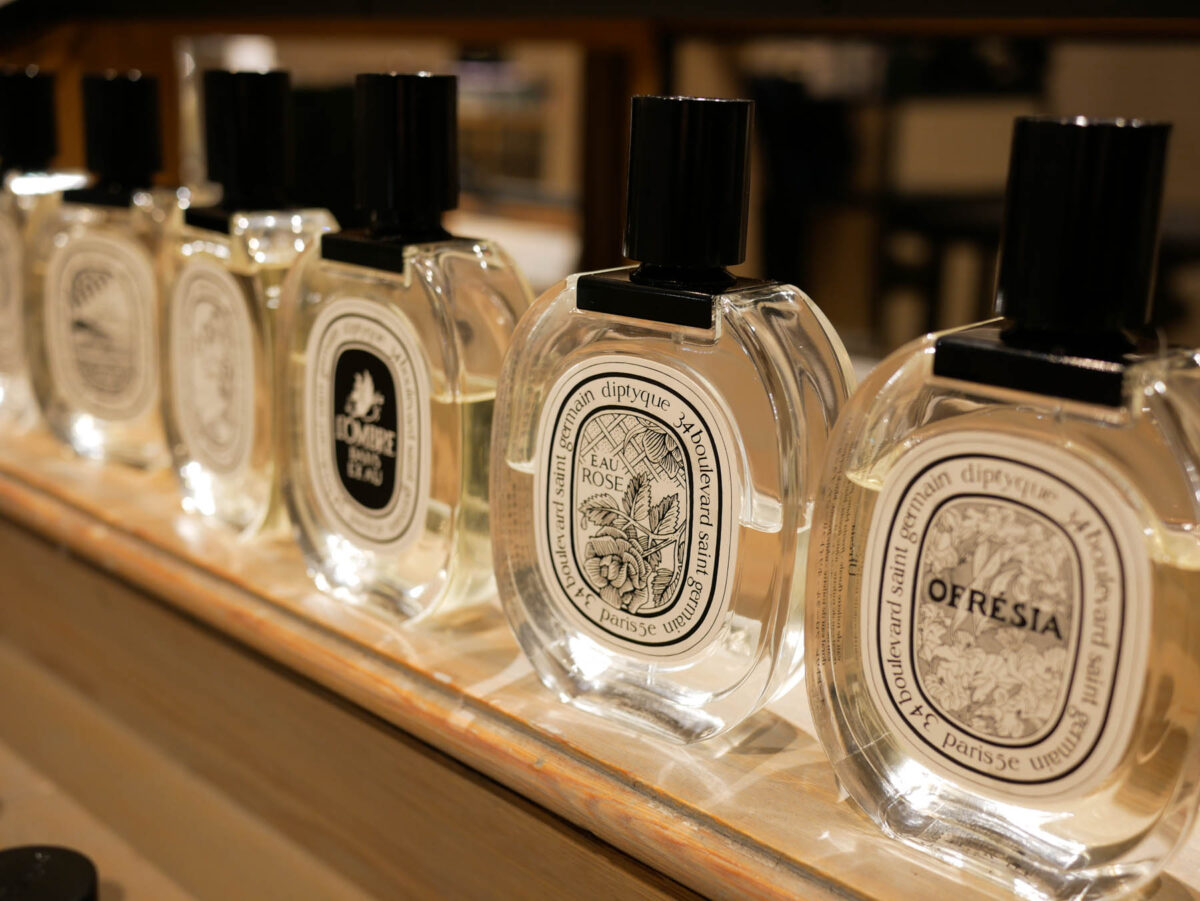 a shelf with Diptyque perfumes